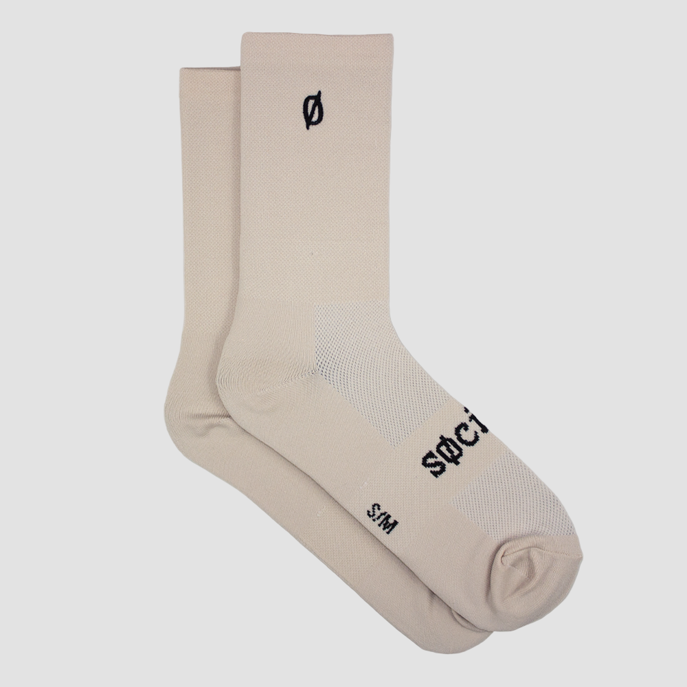 Beige socks with black branding on a light gray background
