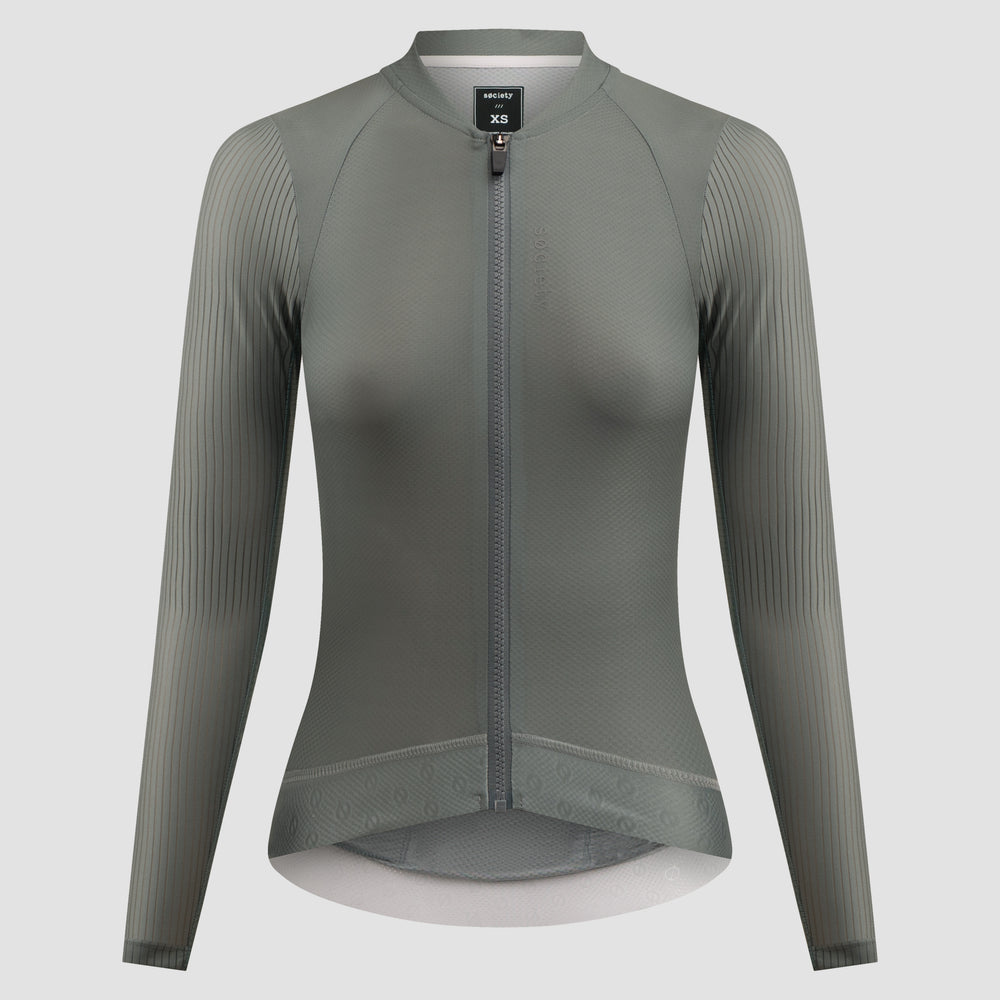 A women's long-sleeve cycling jersey in a muted gray-green color, featuring a full-length front zipper, a stand collar, and vertical ribbed knit sleeves, shown on a neutral light gray background.