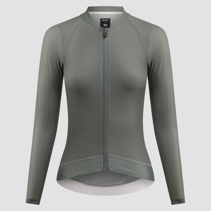 A women's long-sleeve cycling jersey in a muted gray-green color, featuring a full-length front zipper, a stand collar, and vertical ribbed knit sleeves, shown on a neutral light gray background.